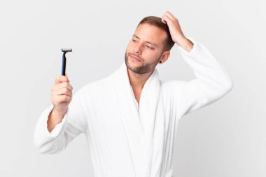 Yakışıklı sarışın adam şaşkın ve kafası karışık, kaşınan bir kafa hissediyor. traş konsepti