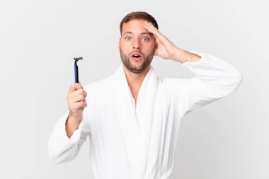 Yakışıklı sarışın adam mutlu, şaşkın ve şaşırmış görünüyor. traş konsepti