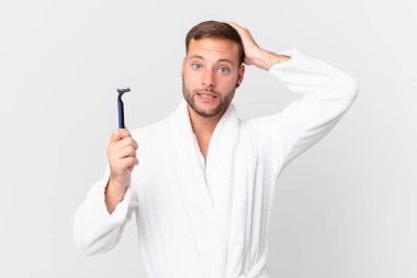 Yakışıklı sarışın adam stresli, endişeli ya da korkmuş, elleri başının üstünde. traş konsepti