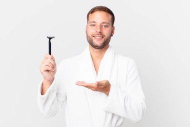 Yakışıklı sarışın adam neşeyle gülümsüyor, mutlu hissediyor ve bir konsept gösteriyor. traş konsepti