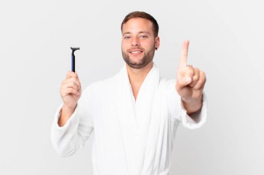 Yakışıklı sarışın adam gururla gülümsüyor ve kendinden emin bir numara oluyor. traş konsepti