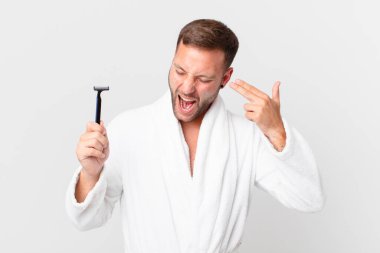 Yakışıklı sarışın adam mutsuz ve stresli görünüyor, intihar jesti silah işareti yapıyor. traş konsepti