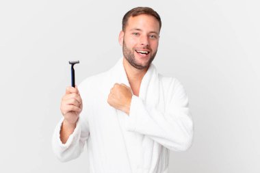 Yakışıklı sarışın adam kendini mutlu hissediyor ve bir meydan okumayla yüzleşiyor ya da kutluyor. traş konsepti