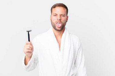 Yakışıklı sarışın adam iğreniyor, sinirleniyor ve dilini çıkarıyor. traş konsepti