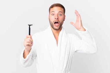 Yakışıklı sarışın adam ellerini havaya kaldırarak çığlık atıyor. traş konsepti