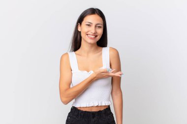 İspanyol güzel kadın neşeyle gülümsüyor, mutlu hissediyor ve bir konsept gösteriyor.