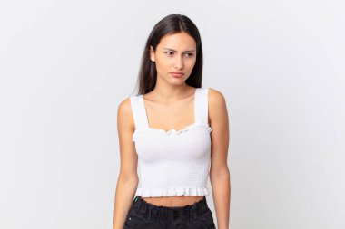 İspanyol güzel kadın üzgün, üzgün ya da kızgın hissediyor ve yan tarafa bakıyor.