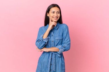 İspanyol güzel kadın mutlu bir şekilde gülümsüyor ve hayal kuruyor ya da şüphe ediyor