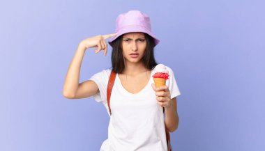 İspanyol turistlerin kafası karışık ve kafası karışık. Deli olduğunu ve elinde dondurma tuttuğunu gösteriyor.