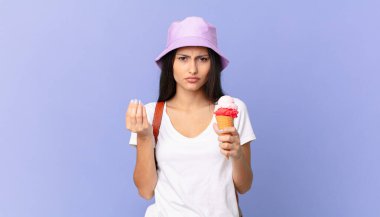 Güzel İspanyol turist kapiş ya da para jesti yapıyor, sana ödeme yapmanı ve dondurma tutmanı söylüyor.