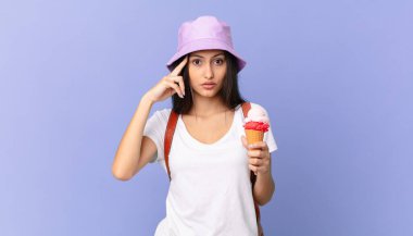 İspanyol turist şaşırmış görünüyor, yeni bir düşünce, fikir ya da konsept buluyor ve dondurma tutuyor.