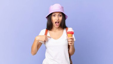 Oldukça İspanyol bir turist ağzı açık, kendini işaret eden ve elinde dondurma tutan şaşkın ve şaşırmış görünüyor.