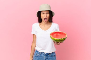 Saldırganca bağırıyor, çok sinirli görünüyor.