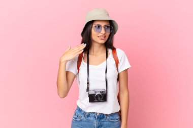 pretty hispanic tourist feeling stressed, anxious, tired and frustrated with a photo camera and a hat