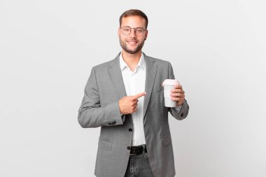 Yakışıklı iş adamı elinde kahve tutuyor.