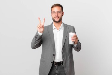 Yakışıklı iş adamı elinde kahve tutuyor.