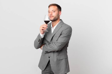 Yakışıklı iş adamı şarap içiyor.