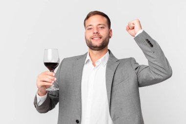 Yakışıklı iş adamı şarap içiyor.