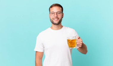 Genç yakışıklı bir adam yarım litre bira içiyor.