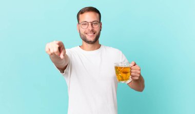 Genç yakışıklı bir adam yarım litre bira içiyor.