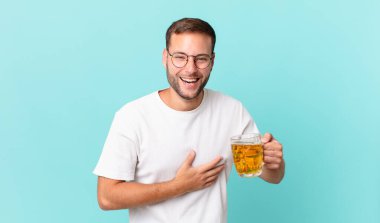 Genç yakışıklı bir adam yarım litre bira içiyor.