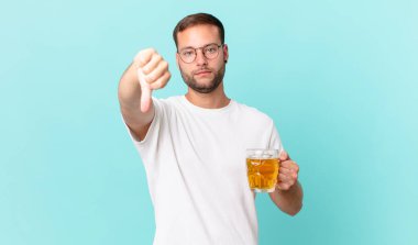 Genç yakışıklı bir adam yarım litre bira içiyor.