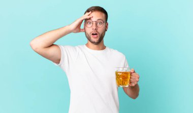 Genç yakışıklı bir adam yarım litre bira içiyor.