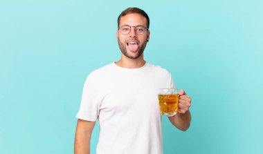 Genç yakışıklı bir adam yarım litre bira içiyor.