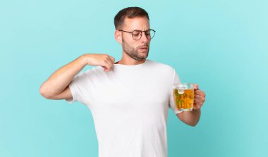 Genç yakışıklı bir adam yarım litre bira içiyor.