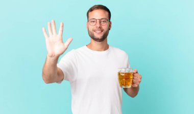 Genç yakışıklı bir adam yarım litre bira içiyor.