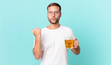 Genç yakışıklı bir adam yarım litre bira içiyor.