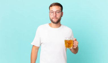 Genç yakışıklı bir adam yarım litre bira içiyor.