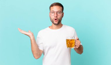 Genç yakışıklı bir adam yarım litre bira içiyor.