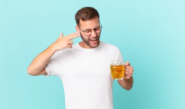 Genç yakışıklı bir adam yarım litre bira içiyor.