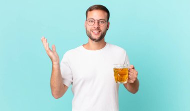 Genç yakışıklı bir adam yarım litre bira içiyor.