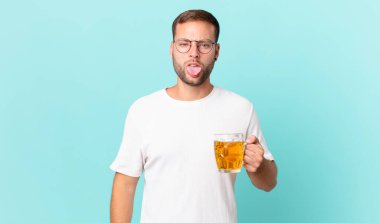 Genç yakışıklı bir adam yarım litre bira içiyor.