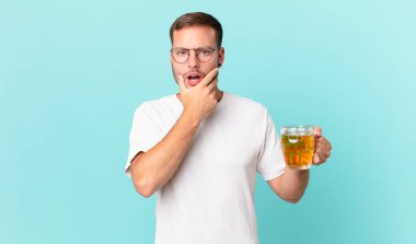 Genç yakışıklı bir adam yarım litre bira içiyor.