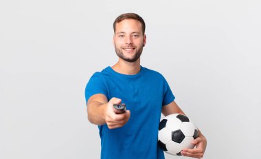 Televizyonda futbol izleyen yakışıklı adam.