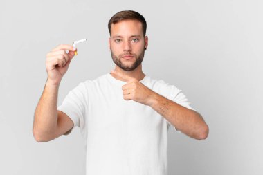 Yakışıklı adam sigarayı kırık bir puroyla bırakıyor.