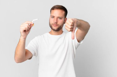 Yakışıklı adam sigarayı kırık bir puroyla bırakıyor.
