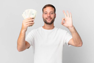 Dolar banknotları olan yakışıklı bir adam.