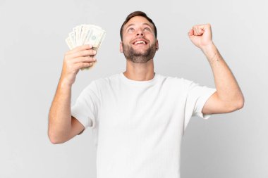 Dolar banknotları olan yakışıklı bir adam.