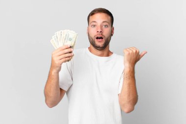 Dolar banknotları olan yakışıklı bir adam.
