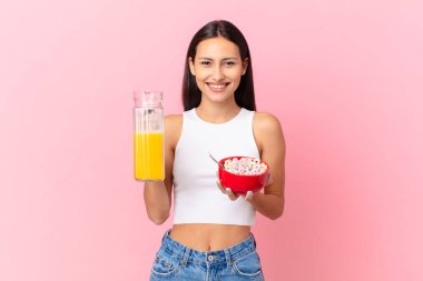 hispanic pretty woman with a breakfast bowl with flakes and orange juice