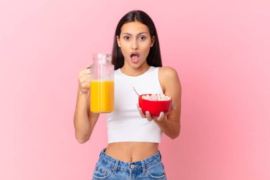 hispanic pretty woman with a breakfast bowl with flakes and orange juice