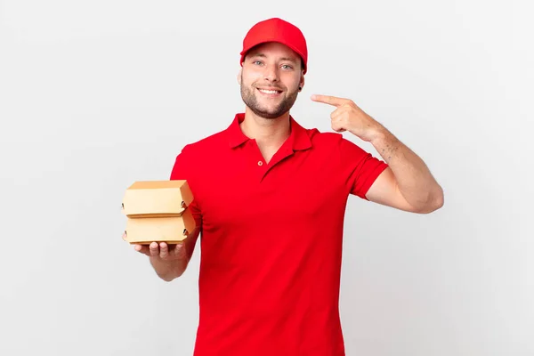 Hamburguesa Entregar Hombre Sonriendo Con Confianza Señalando Propia Sonrisa Amplia —  Fotos de Stock