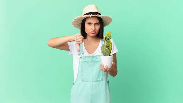 Pretty Farmer Woman Feeling Cross Showing Thumbs Holding Cactus — ストック写真