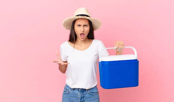 Pretty Hispanic Woman Looking Angry Annoyed Frustrated Holding Portable Refrigerator — Stockfoto