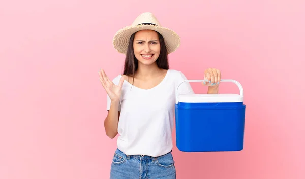 Pretty Hispanic Woman Looking Desperate Frustrated Stressed Holding Portable Refrigerator — Stockfoto