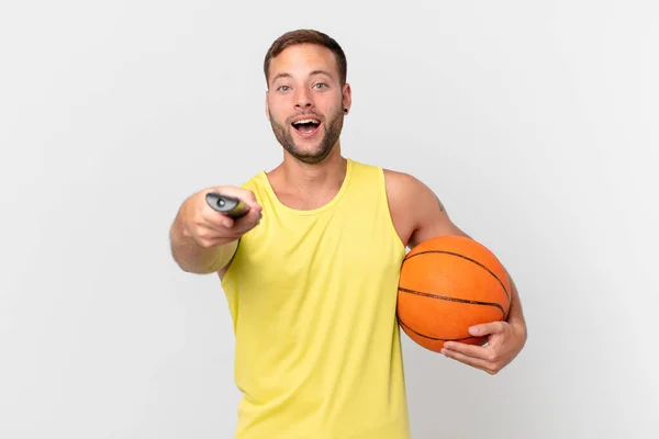 Hombre Guapo Con Una Pelota Baloncesto Elección Canal Con Controlador — Foto de Stock